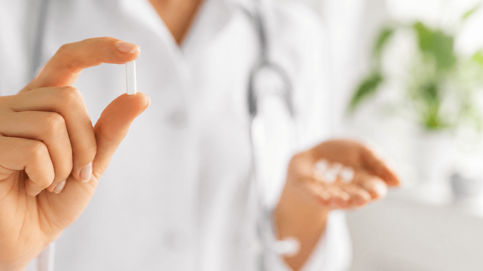 Doctor holding a small hormone pellet during bioidentical hormone therapy